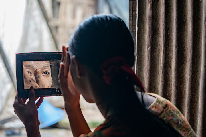 Useaking's from Bangladesh looking in a mirror in side a dark room