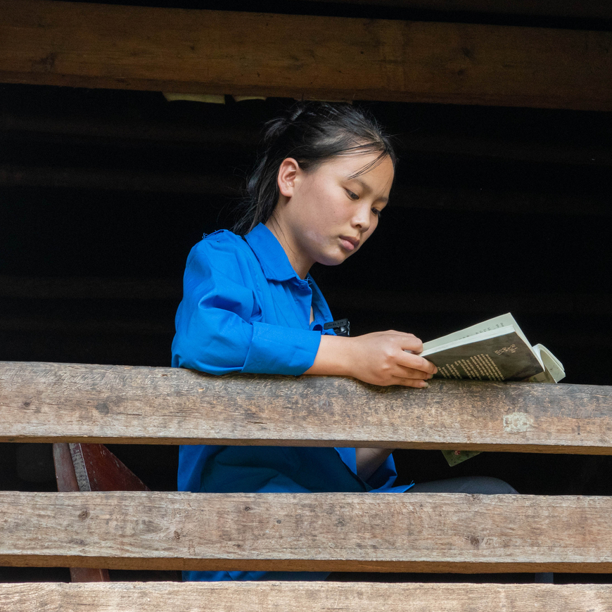 A 15-year-old Vietnamese girl named Ngân reads from her diary, looking thoughtful.