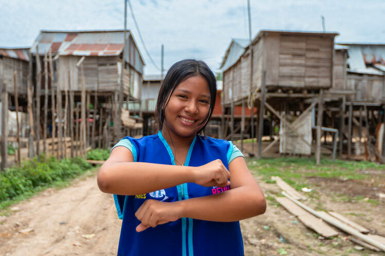 Partner with Plan Canada and be a proud champion for gender equality, adolescent girl from Loreto, Peruvian Amazon holding her arms to represent equal signs