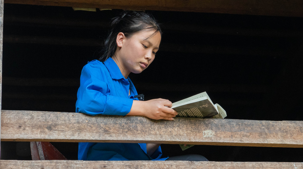 A 15-year-old Vietnamese girl named Ngân reads from her diary, looking thoughtful.