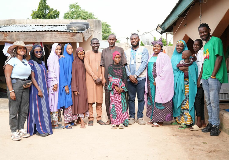 A group photo of a family and a film crew in a yard in Nigeria