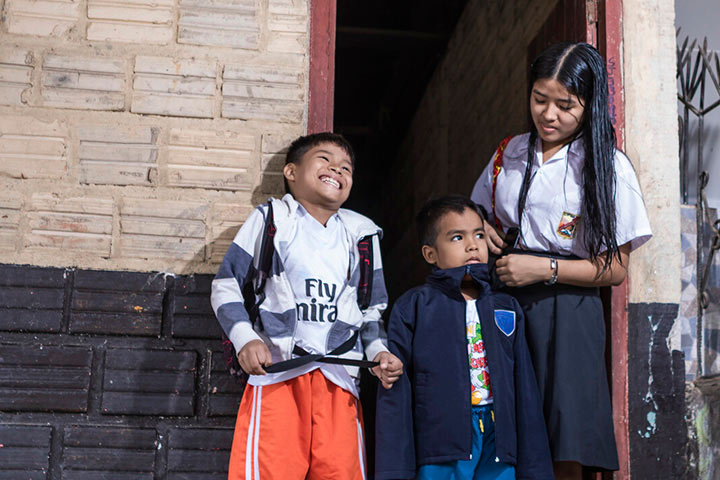 Natsumi smiles next to two younger brother while getting ready for school