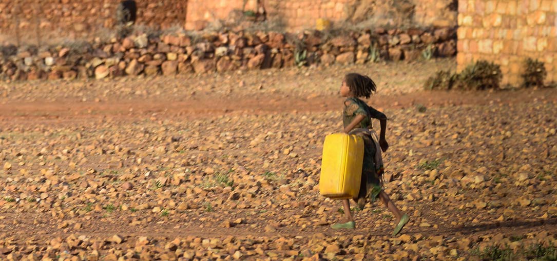 A girl returns to her village in rural Amhara carrying water.