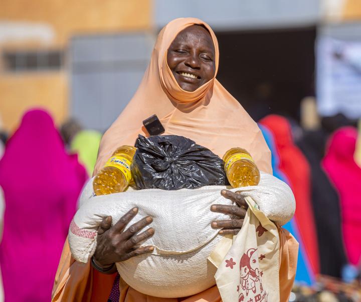 Smiling woman receives food kit during distribution in Tahoua region