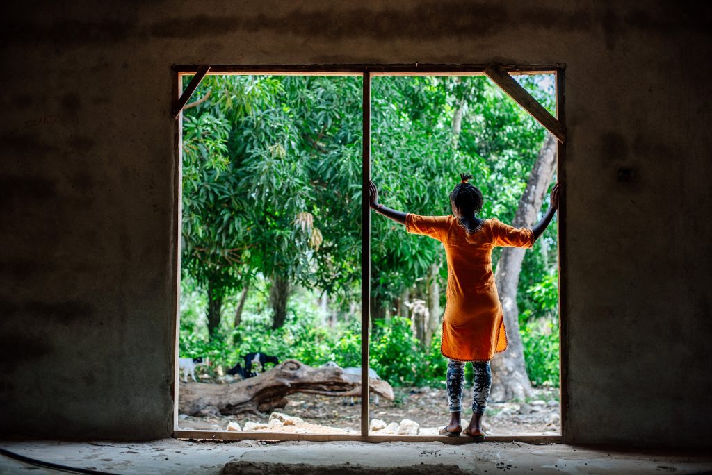 girl standing looking outside