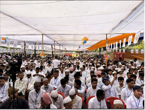 A group of men sitting down and listening to a speech.