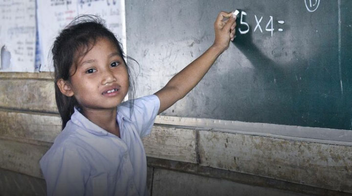 Girl writing on blackboard