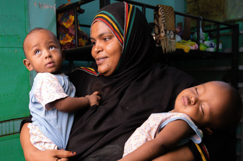 Woman holding two babies