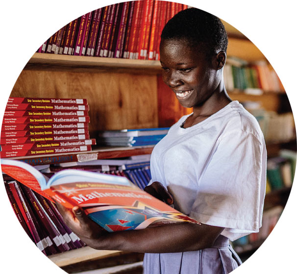 Viola, 17, selects one of the many books in her new school library in Uganda