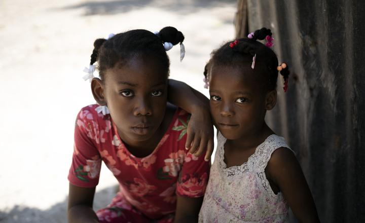 Lettycia, 10, and her cousin sit outside in the shade