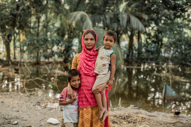 A woman hugging her two children.