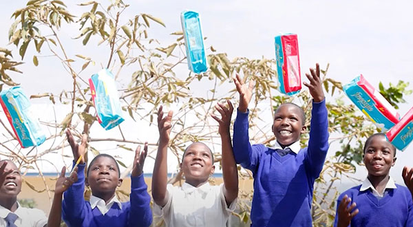 Girls throwing period products into the air