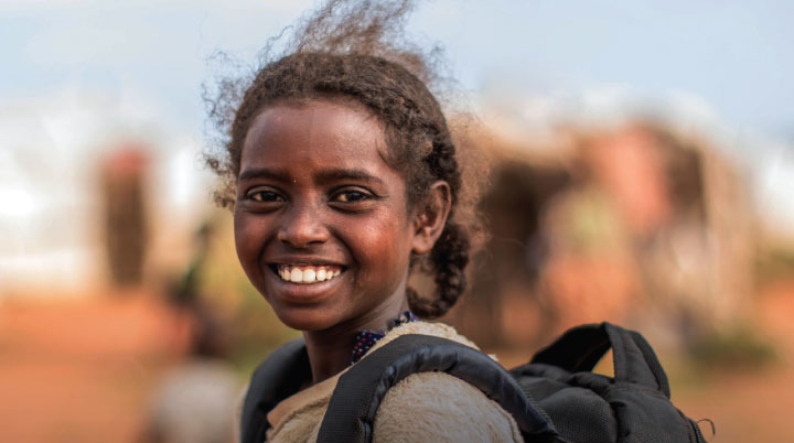 Girl with backpack smiles