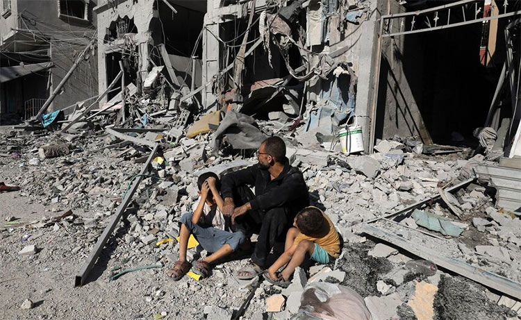 Family sit amid rubble of their home in Rafah