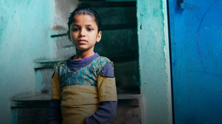 Girl standing by wall