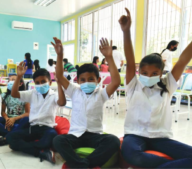 Kids in classroom with hands up