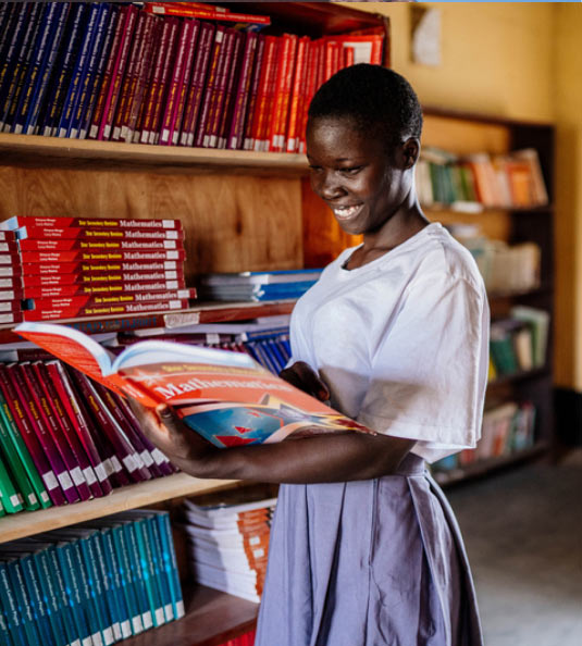 Girl reading book in library