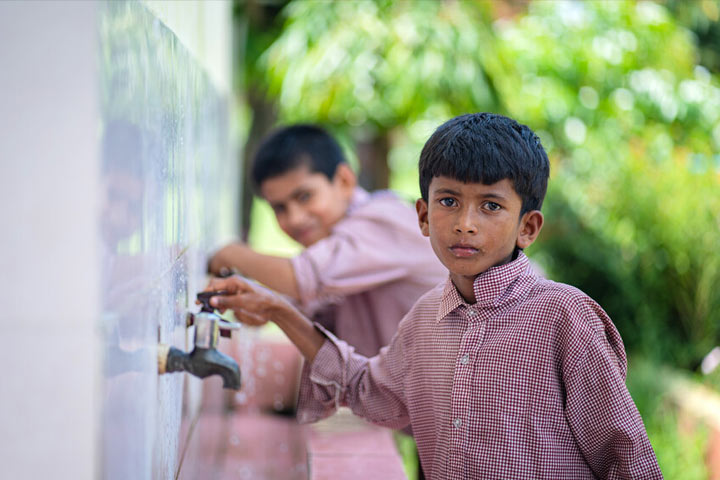 Boy turning on a faucet