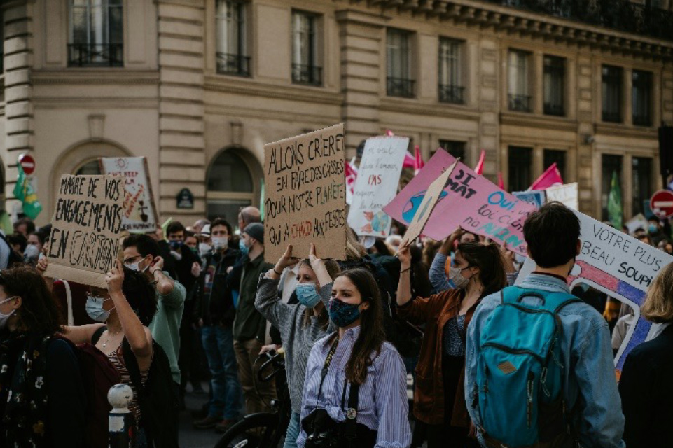 People holding signs and protesting outside on a street in Paris in 2021 