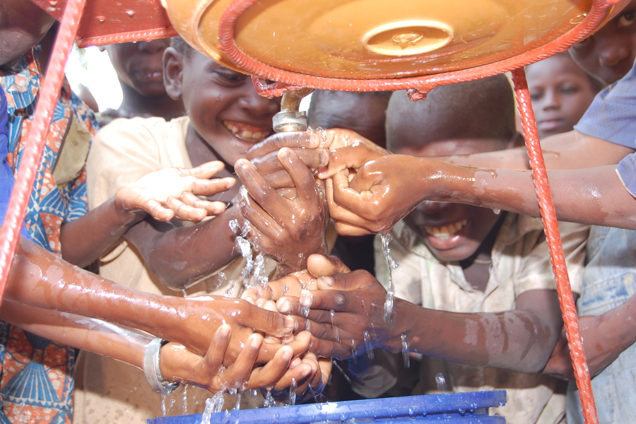 Children wash their hands at a hand-washing facility in Benin.
