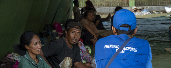 Emergency Response Team worker sitting in a tent with a group of people