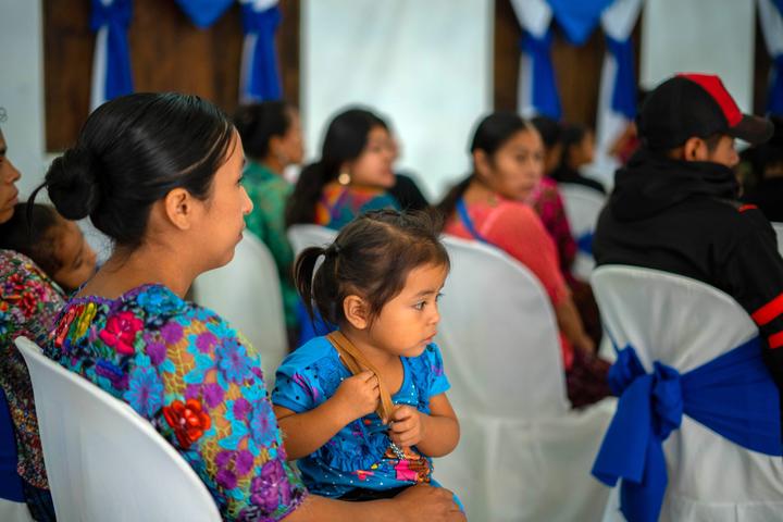 Norma and her daughter attend talk before receive cash transfer