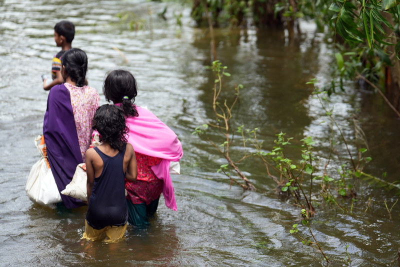  Children walking through floodwaters.
