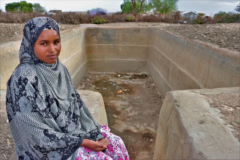 Badra, 16, sits next to her village’s empty water tank in Somalia, where drought caused by climate change is causing the worst hunger crisis in decades.