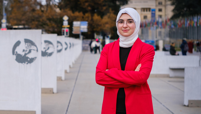 young woman in hijab in front of UN building