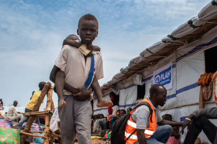 Young boy carrying child