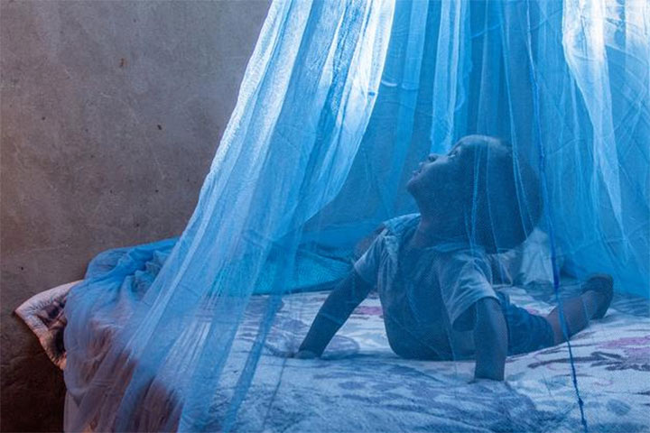 Child under mosquito net.