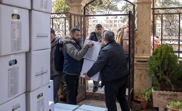 People staying in shelters collect hygiene kits during distribution