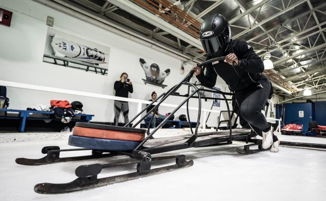 Action shot of an athlete in training pushing a bobsleigh on ice