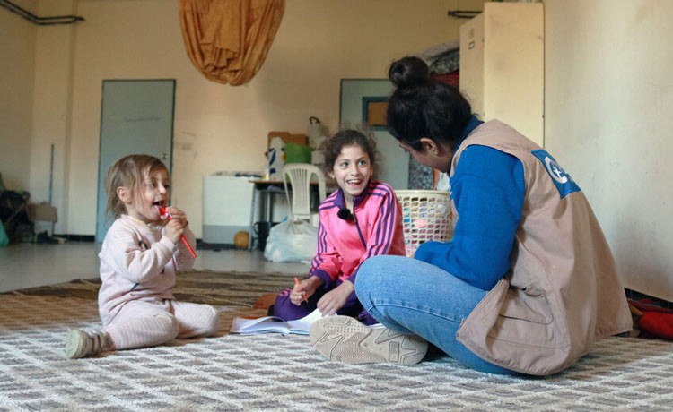 Eleen, 8, enagages with Plan staff member at the IDP shelter  .