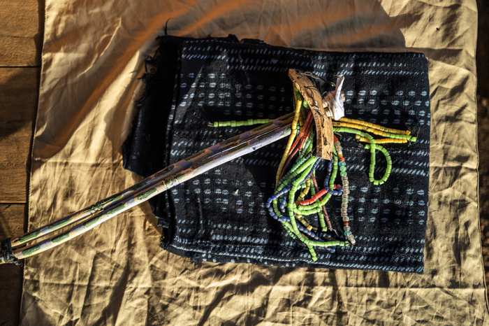 A stick decorated with beads at the top is resting on a loincloth.