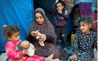 A woman and her three children gathered together in front of a tent in northern Gaza.