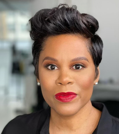 A professional headshot of a woman wearing a black collared shirt.
